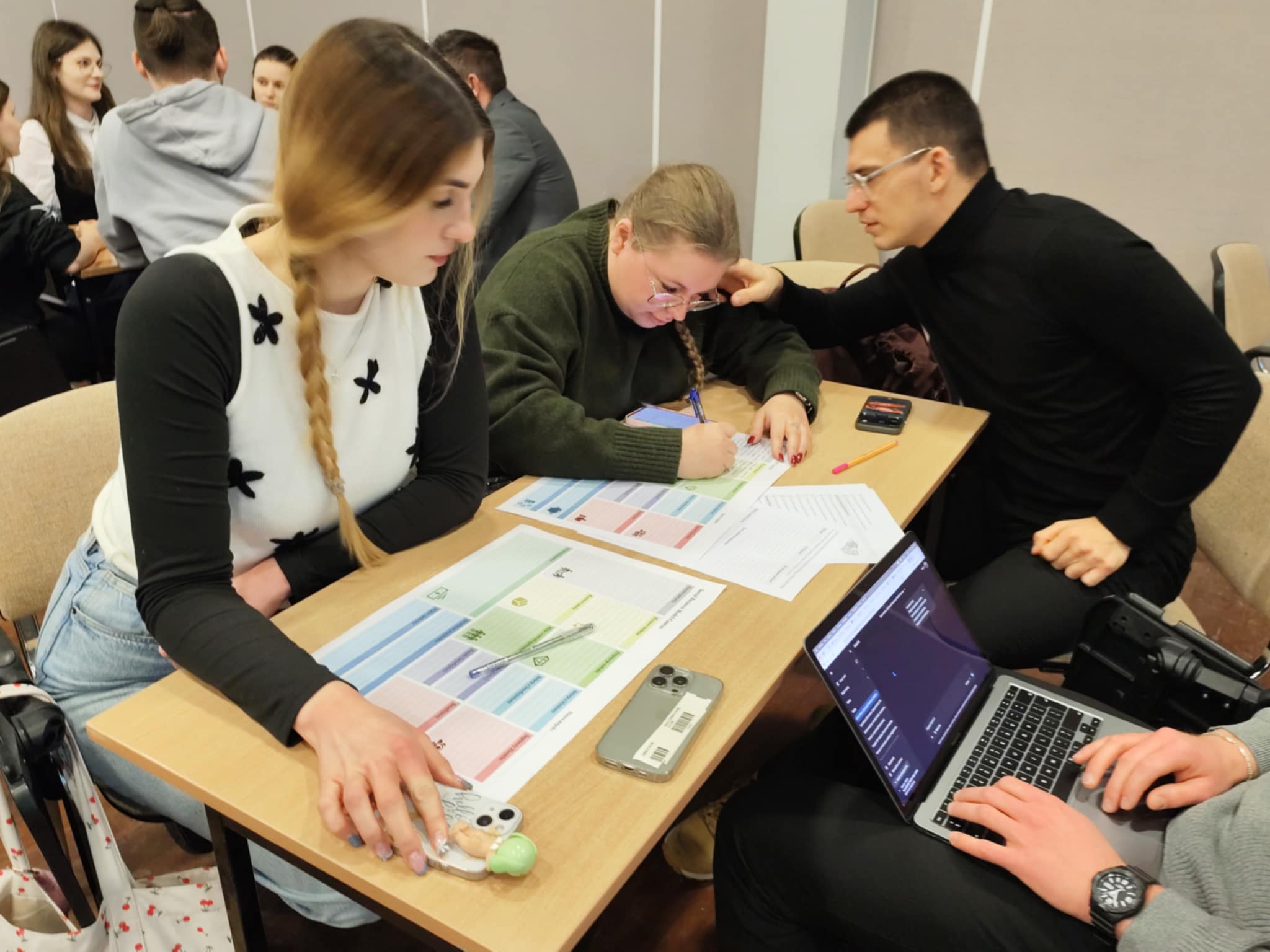 studenci siedzą i omawiają plan biznesowy przedsiębiorstwa społecznego