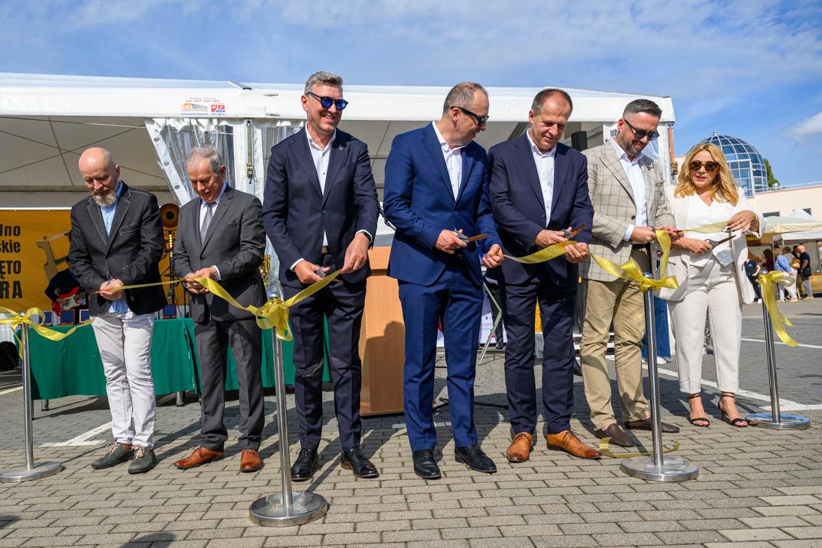 Zdjęcie przedstawia kilka osób przecinających wstęgę