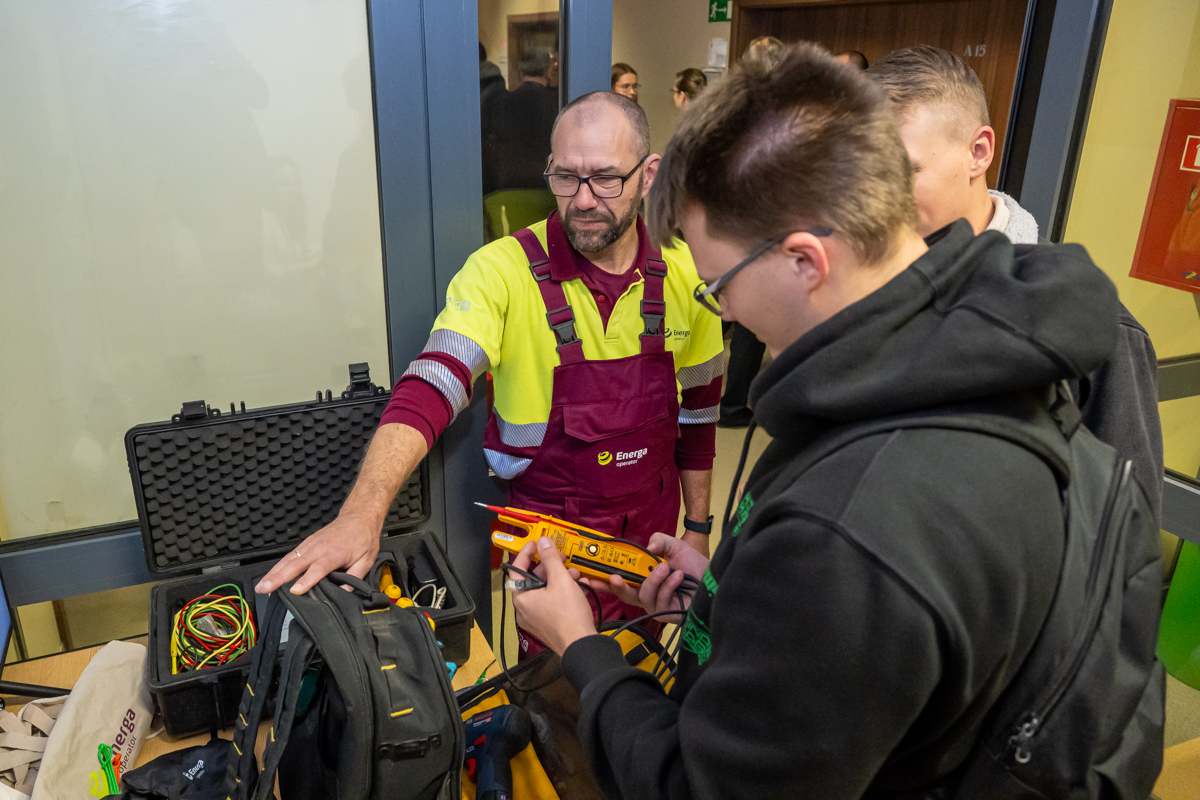 studenci stoją naprzeciwko stoiska Energa i oglądają narzędzia