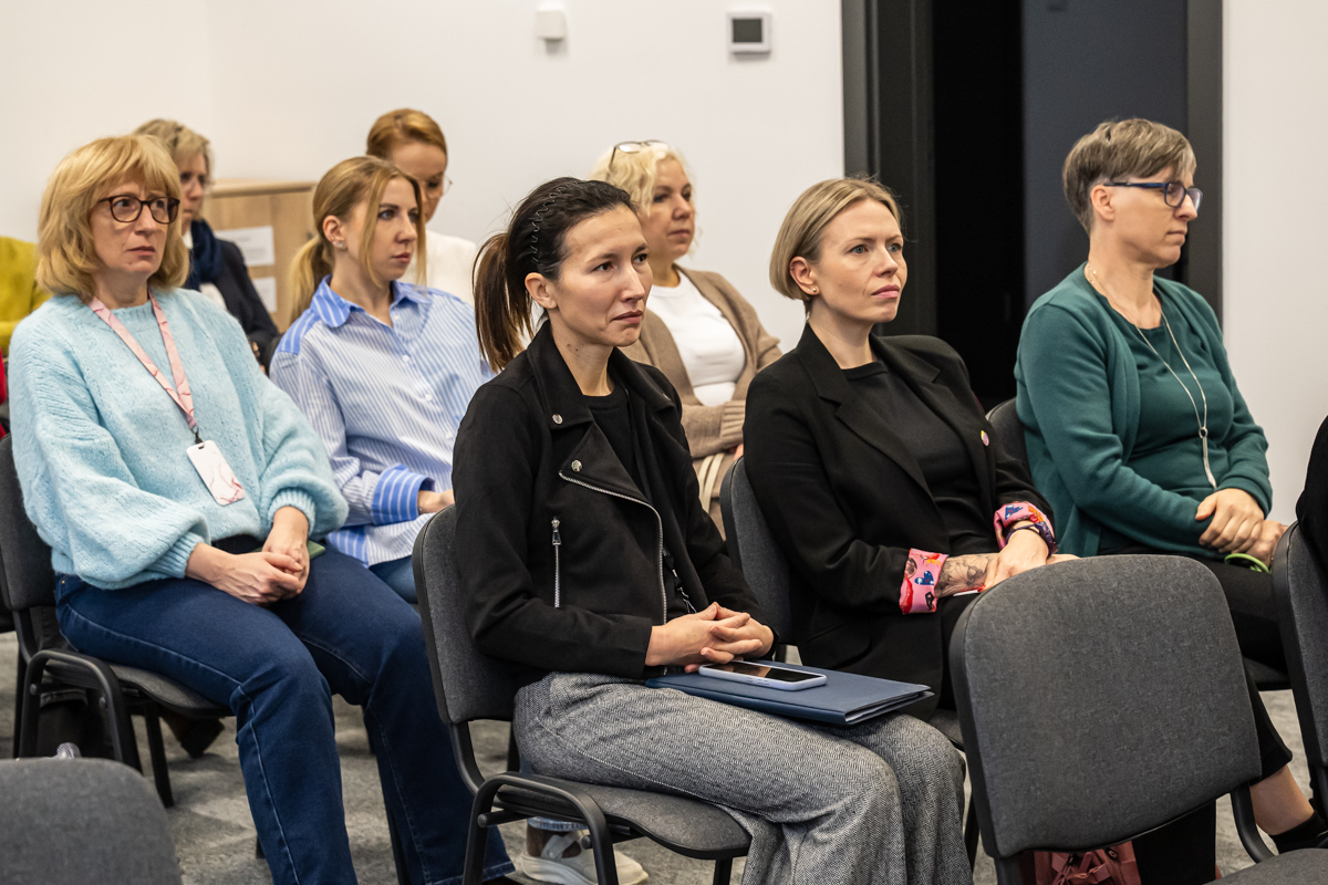 osoby siedzą i słuchają wystąpień