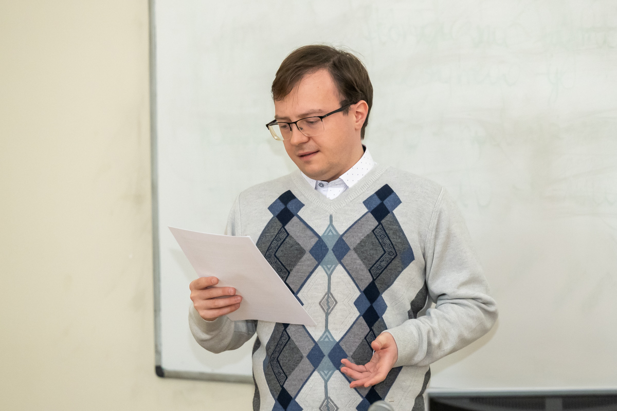 osoba stoi, trzyma kartkę w ręku