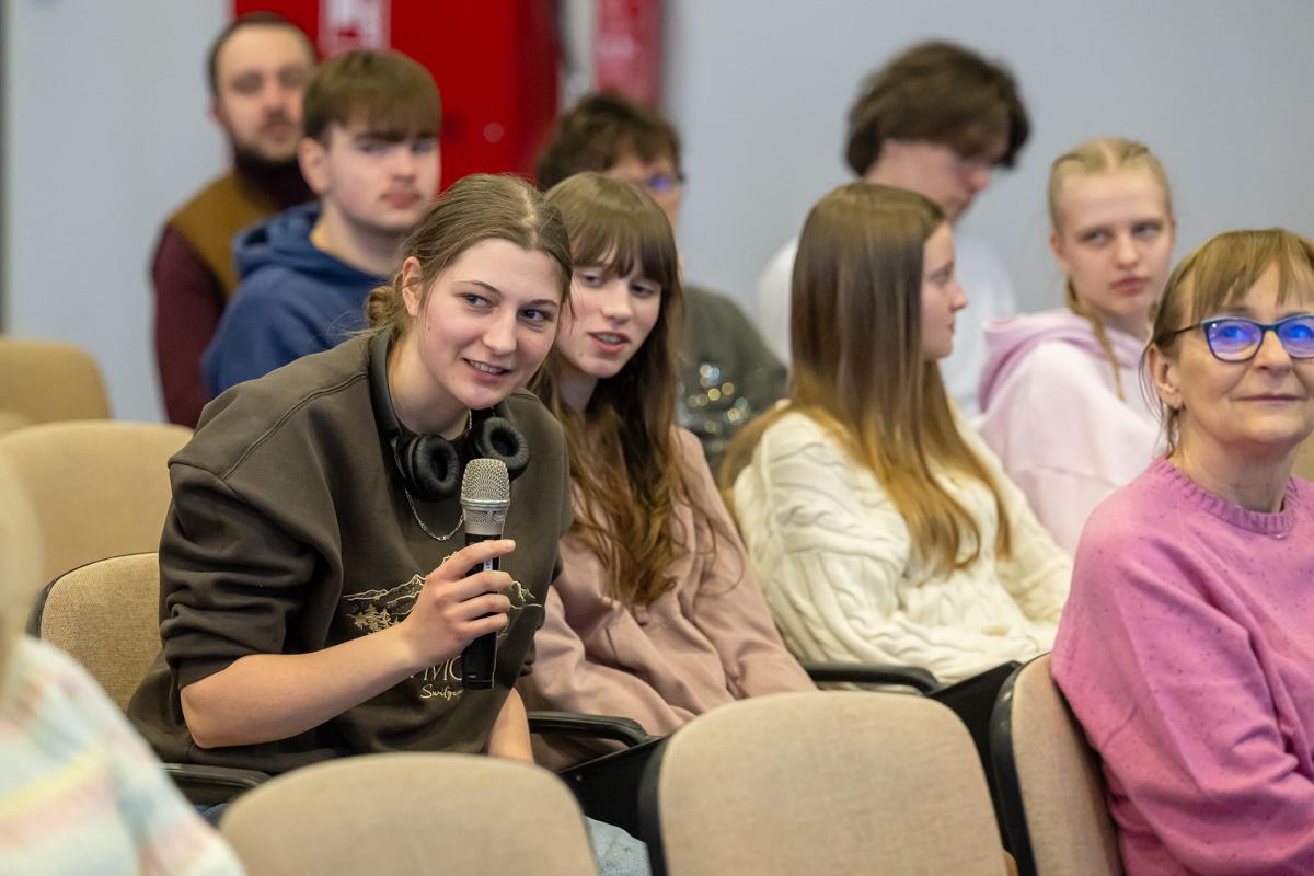 Uczestniczka spotkania zadaje pytanie prowadzącym wykład