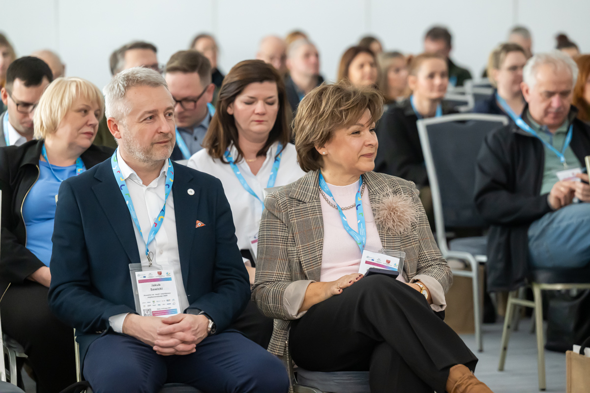 uczestnicy konferencji siedzą w sali konferencyjnej