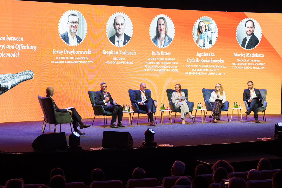 Uczestnicy panelu siedzą na scenie