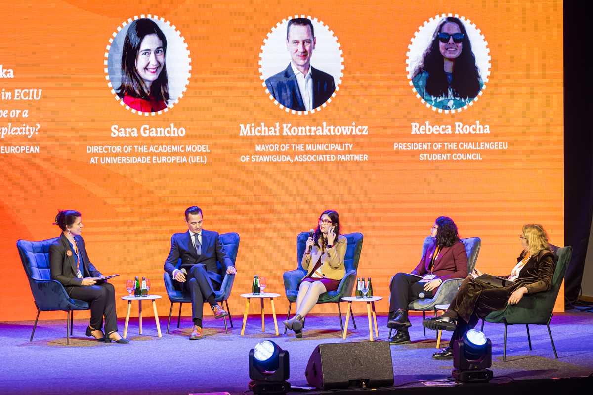 Uczestnicy panelu siedzą na scenie