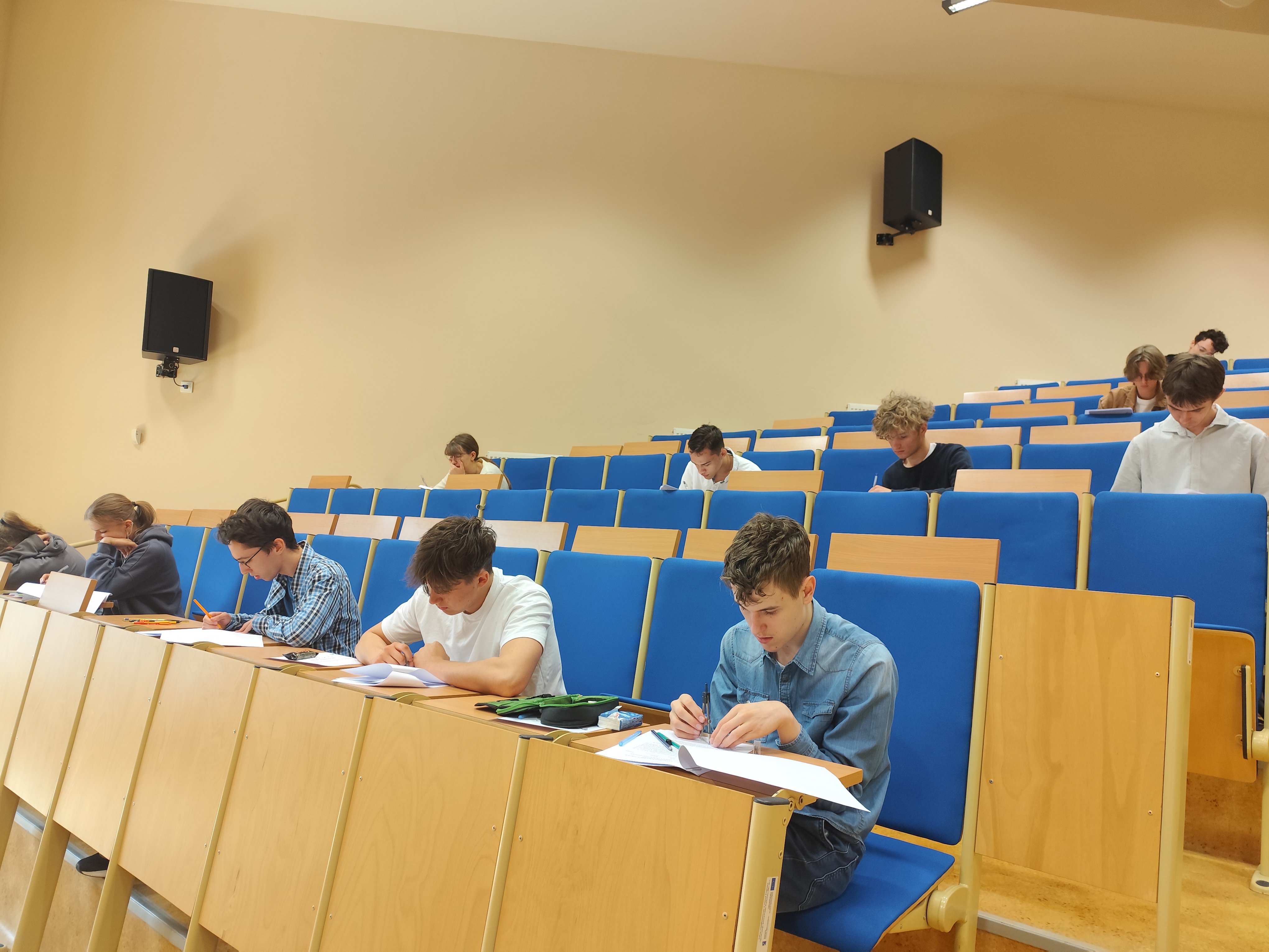 uczniowie siedzą w ławkach i rozwiązują zadania matematyczne