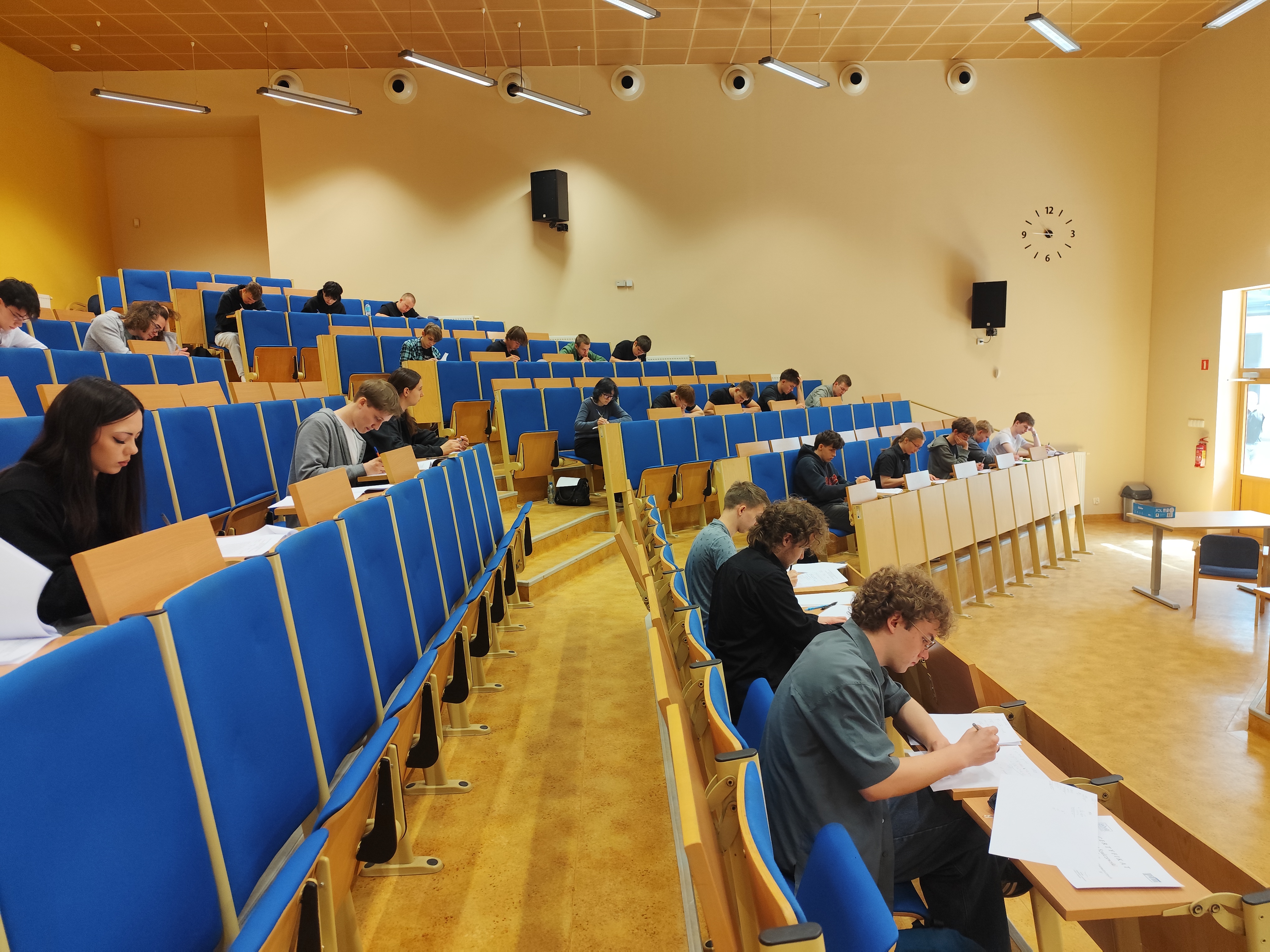 uczniowie siedzą w ławkach i rozwiązują zadania matematyczne