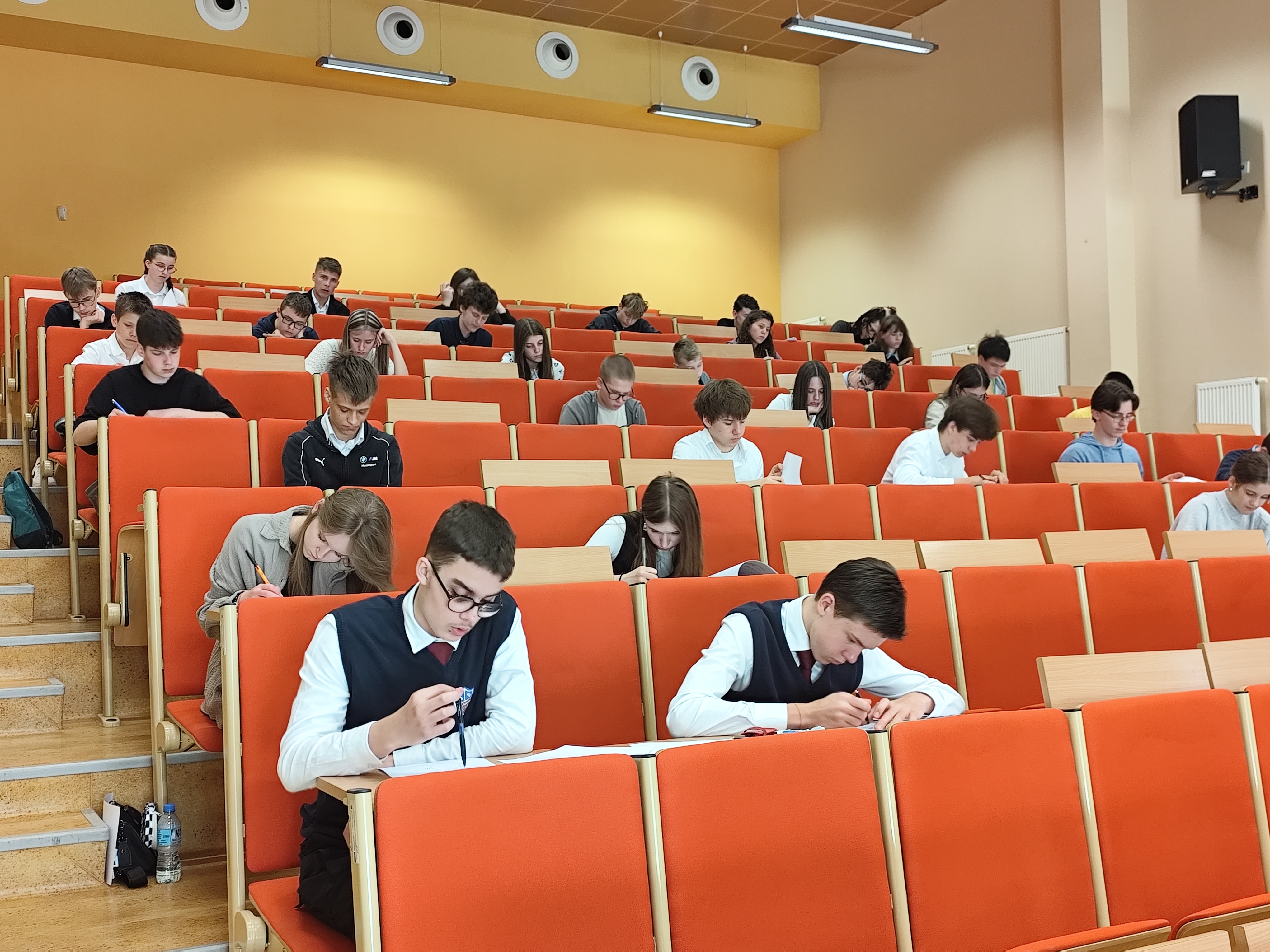uczniowie siedzą w ławkach i rozwiązują zadania matematyczne