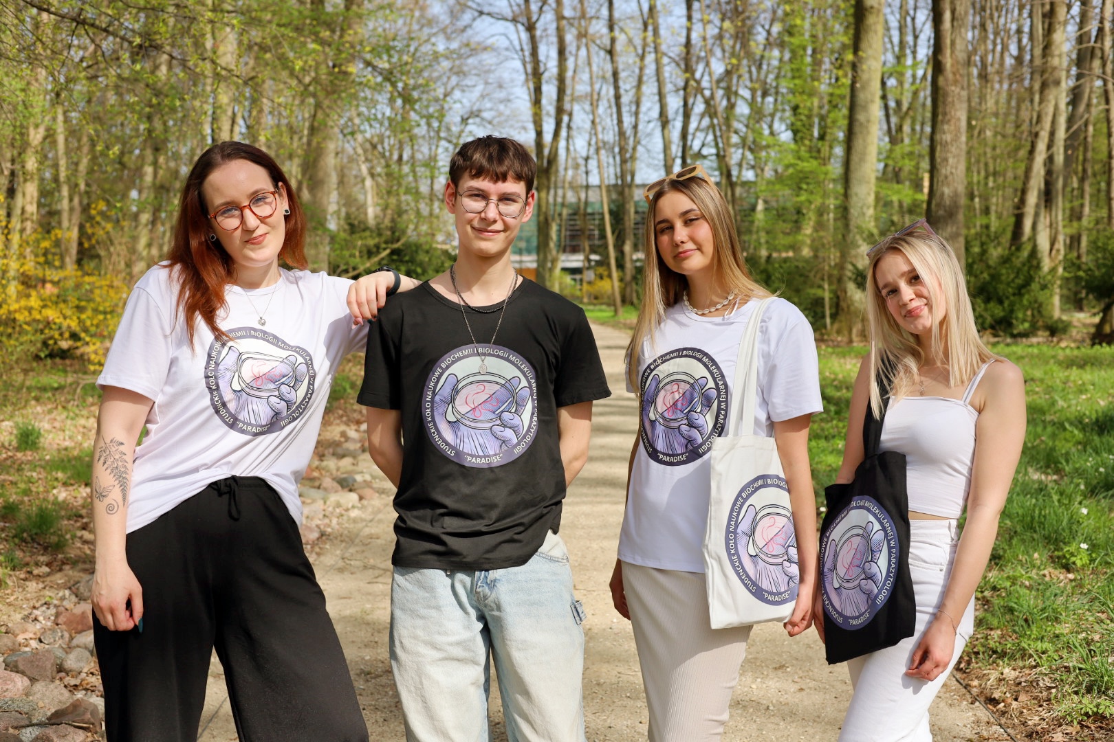 osoby stoją w parku kortowskim, mają na sobie koszulki z logo koła naukowego