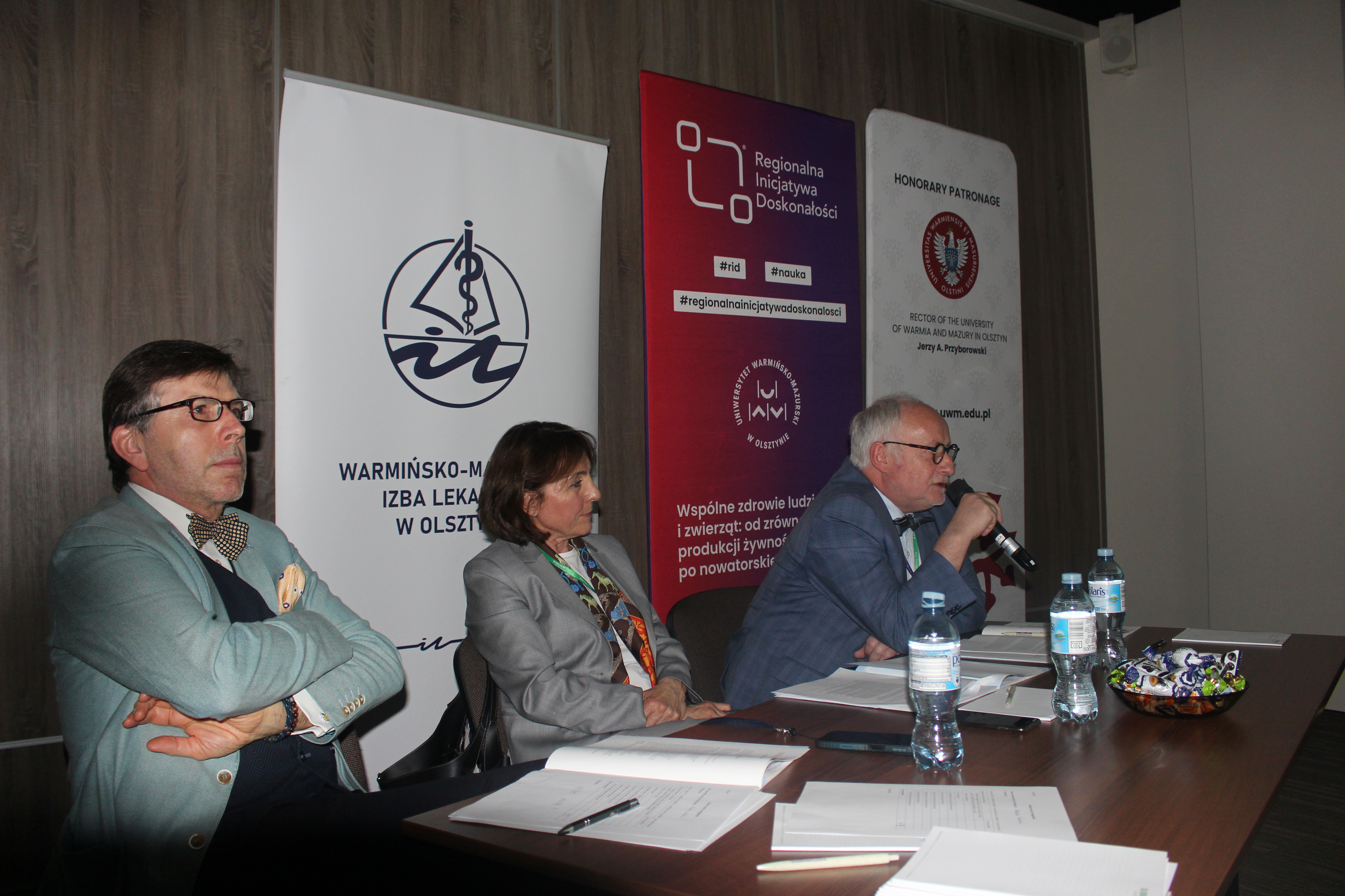 Troje jurorów siedzi, w tle ścianki promocyjne