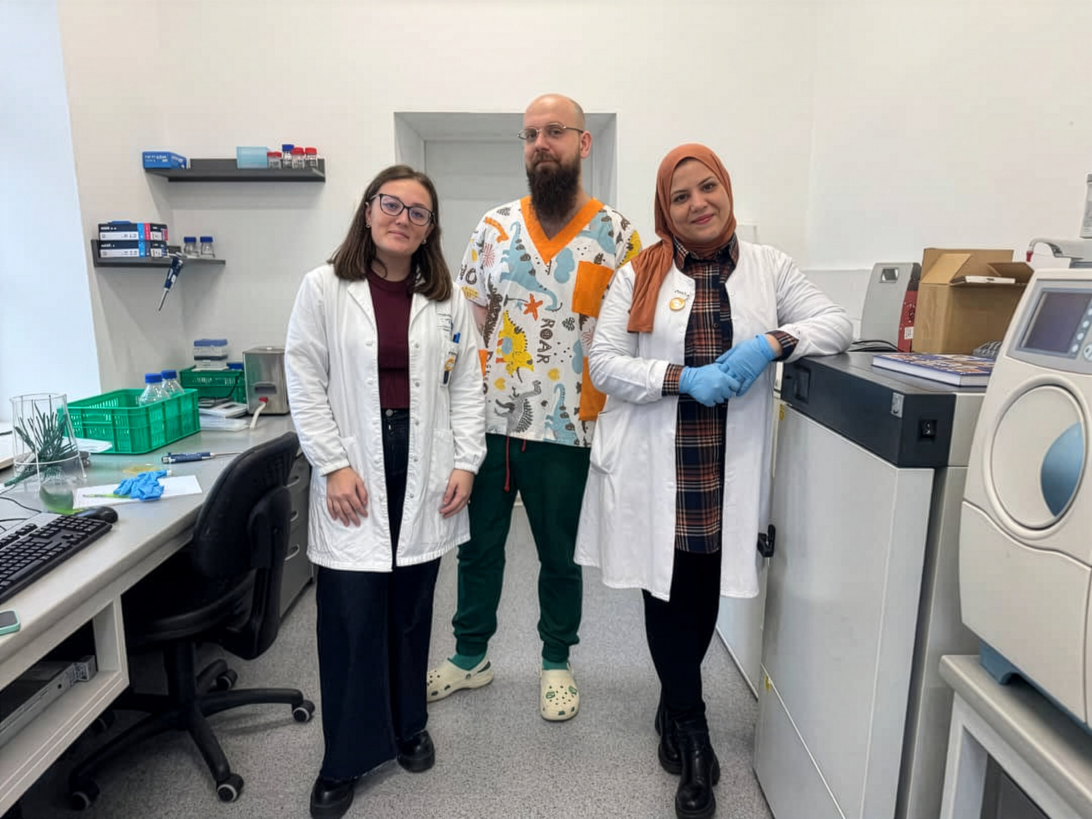 Chiara Pisana i Somia Hallaci w towarzystwie dr. inż. Arkadiusza Zakrzewskiego stoją w laboratorium Katedry Mikrobiologii Żywności, Technologii i Chemii Mięsa na Wydziale Nauki o Żywności