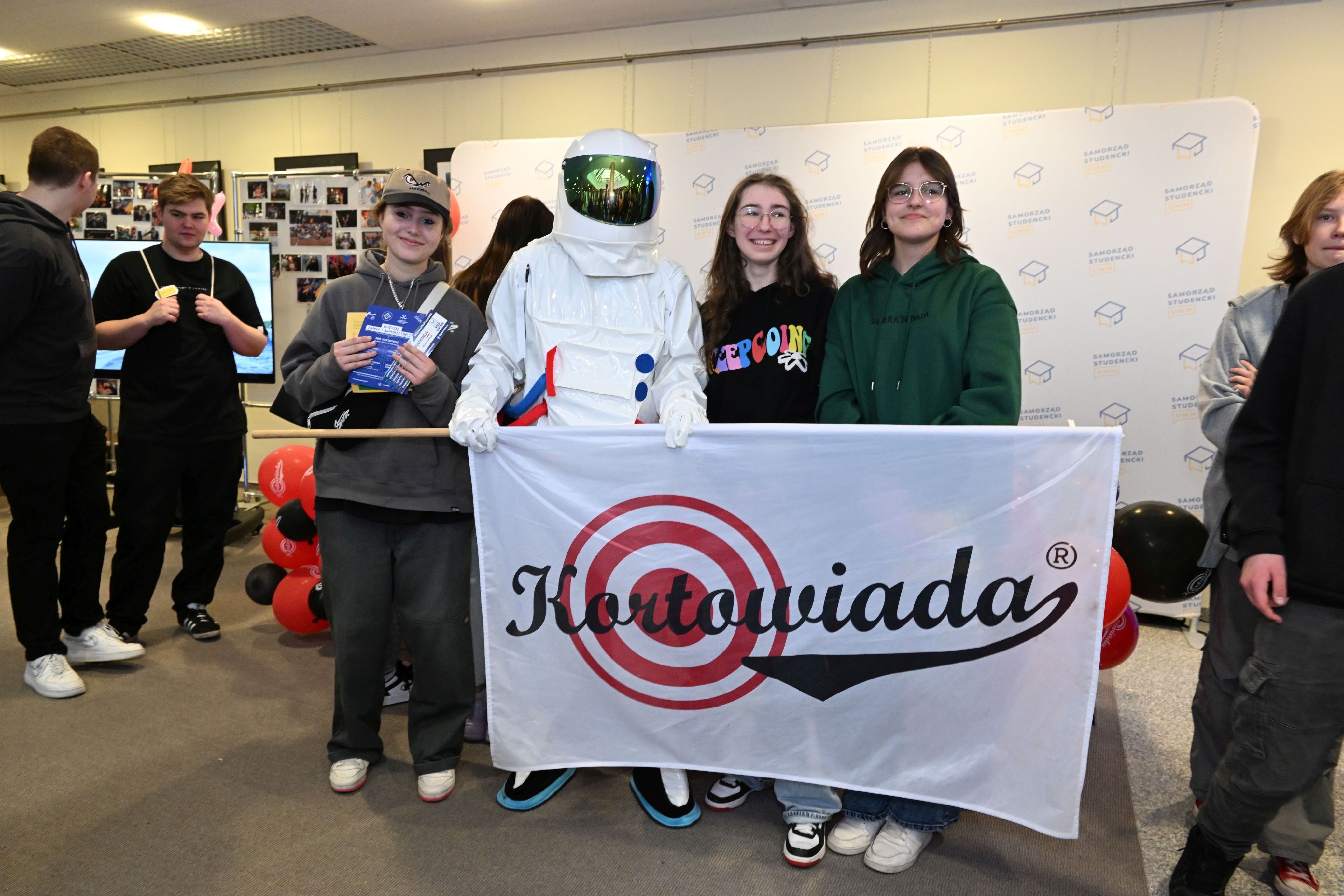 Dzień Otwarty UWM 2023 - Astronauta pozuje do zdjęcia z flagą Kortowiady