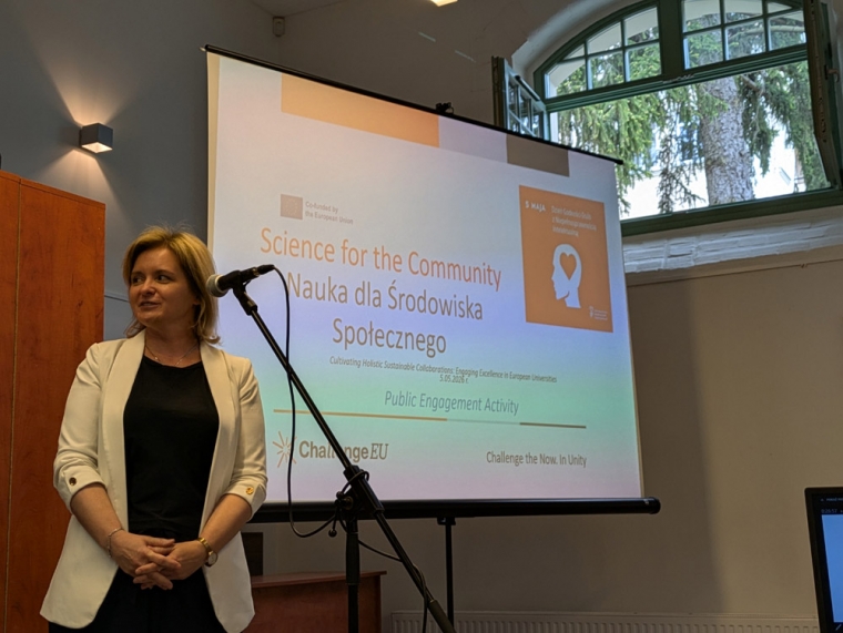 Katarzyna Ćwirynkało podczas Dnia Godności Osób z Niepełnosprawnością Intelektualną, w tle plansza z napisem Nauka dla środowiska społecznego i logo sojuszu ChallengeEU