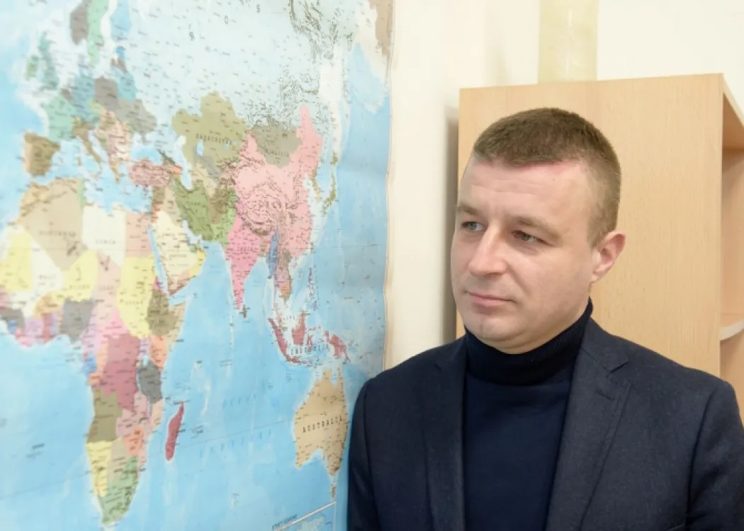 prof. Żęgota na tle mapy świata