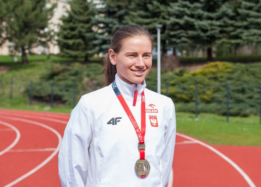 Aleksanda Lisowska z  AZS UWM stoi z medalem na stadionie