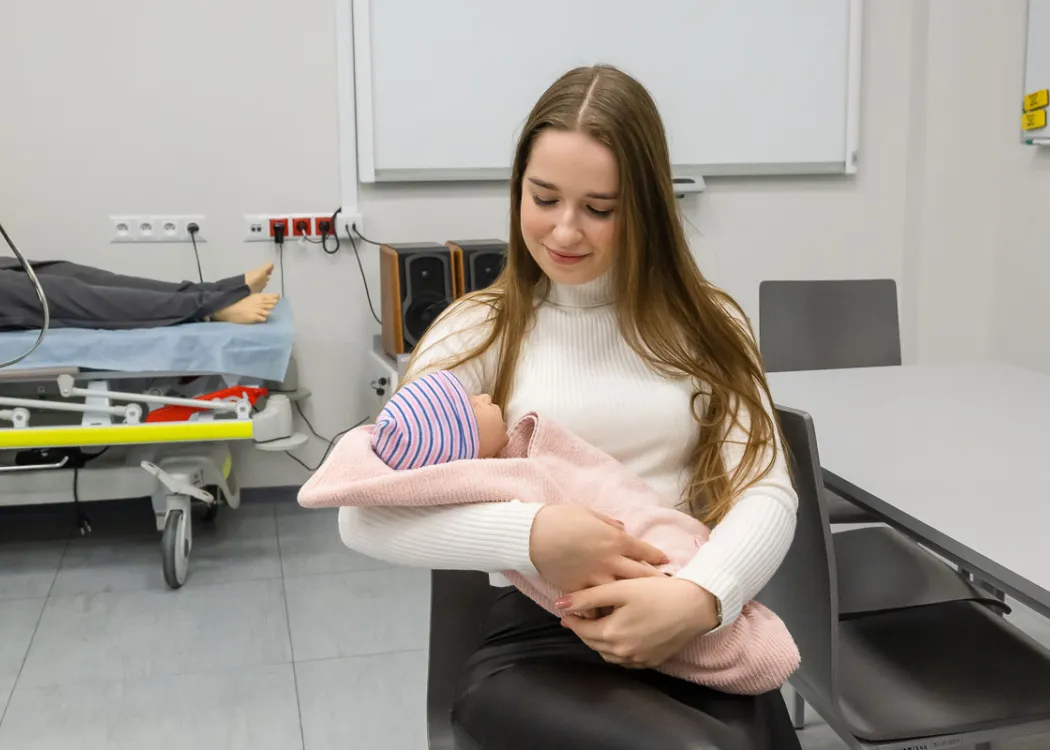 studentka trzyma na ręku manekina dziecko
