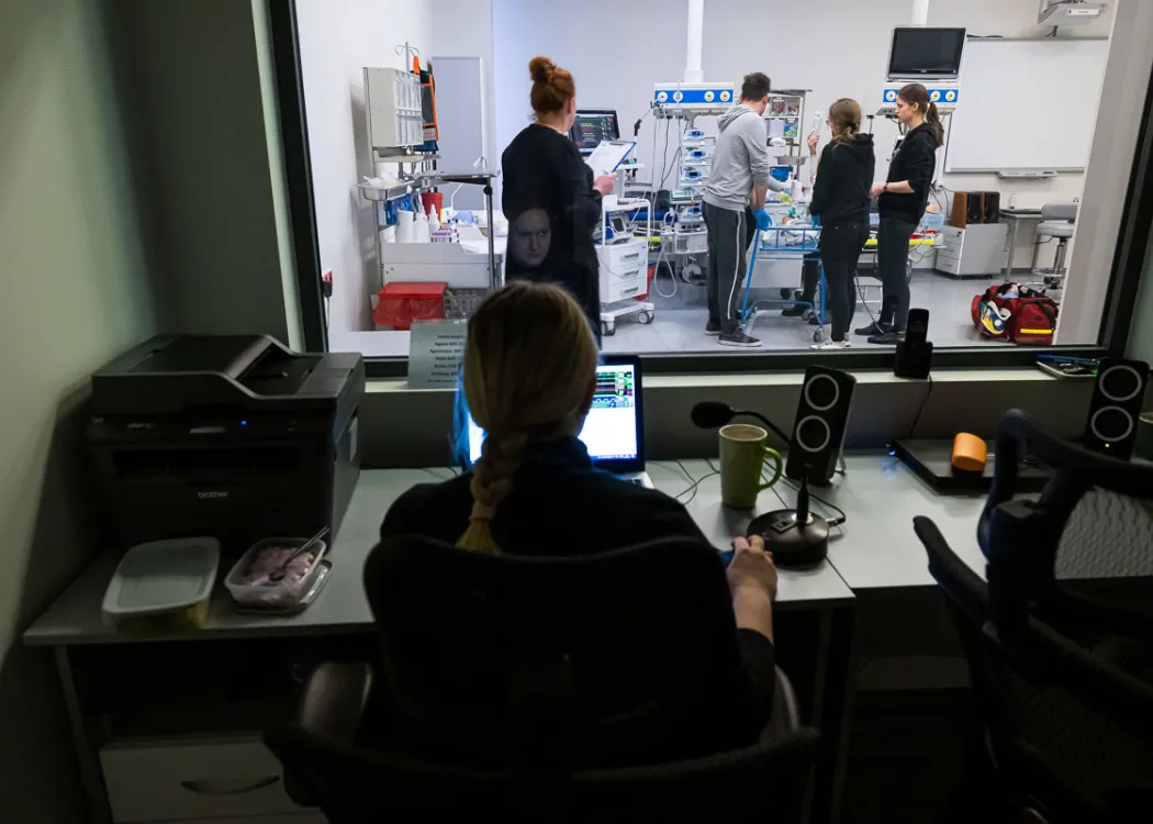 widok przez szybę na studentów w akcji
