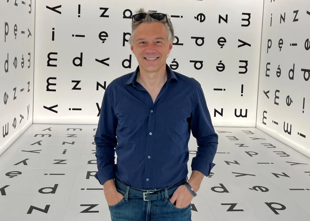 Prof. Mariusz Rutkowski na tle liter