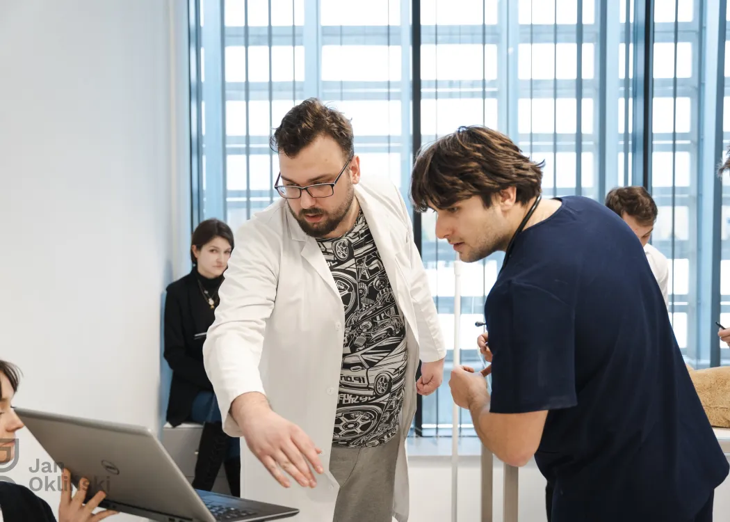 studenci oglądają coś na ekranie koputera