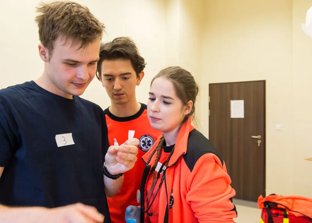 studenci oglądają strzykawkę
