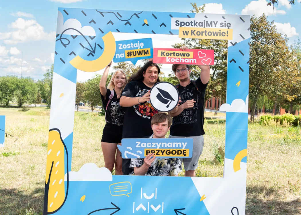 Nowi studenci UWM pozują do zdjęcia w ramce