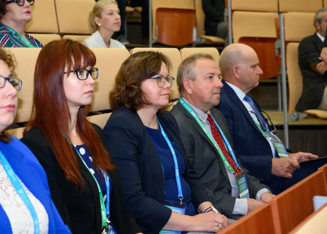 Uczestnicy siedzą i słuchają 