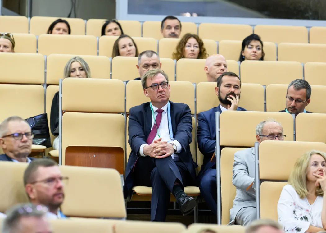 Uczestnicy siedzą i słuchają 