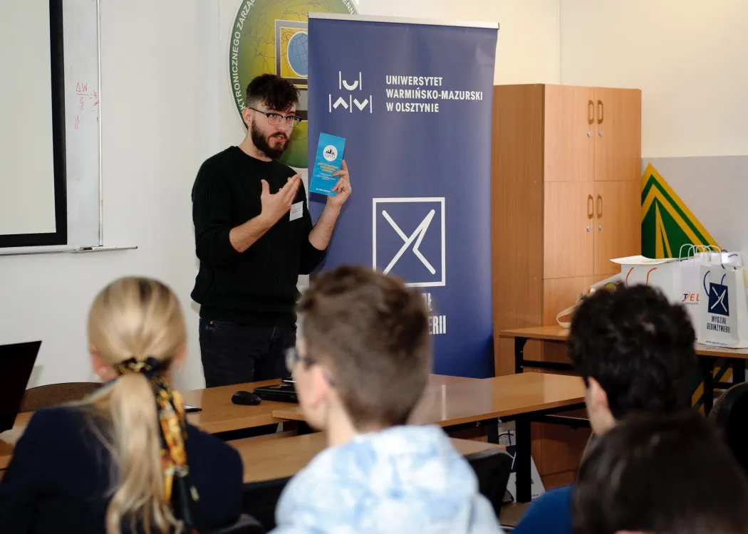 student stoi przed tablicą i coś mówi