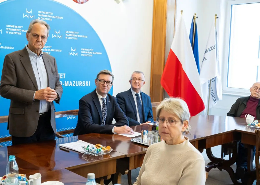 dr Bruder stoi i wita  gospodarzy spotkania