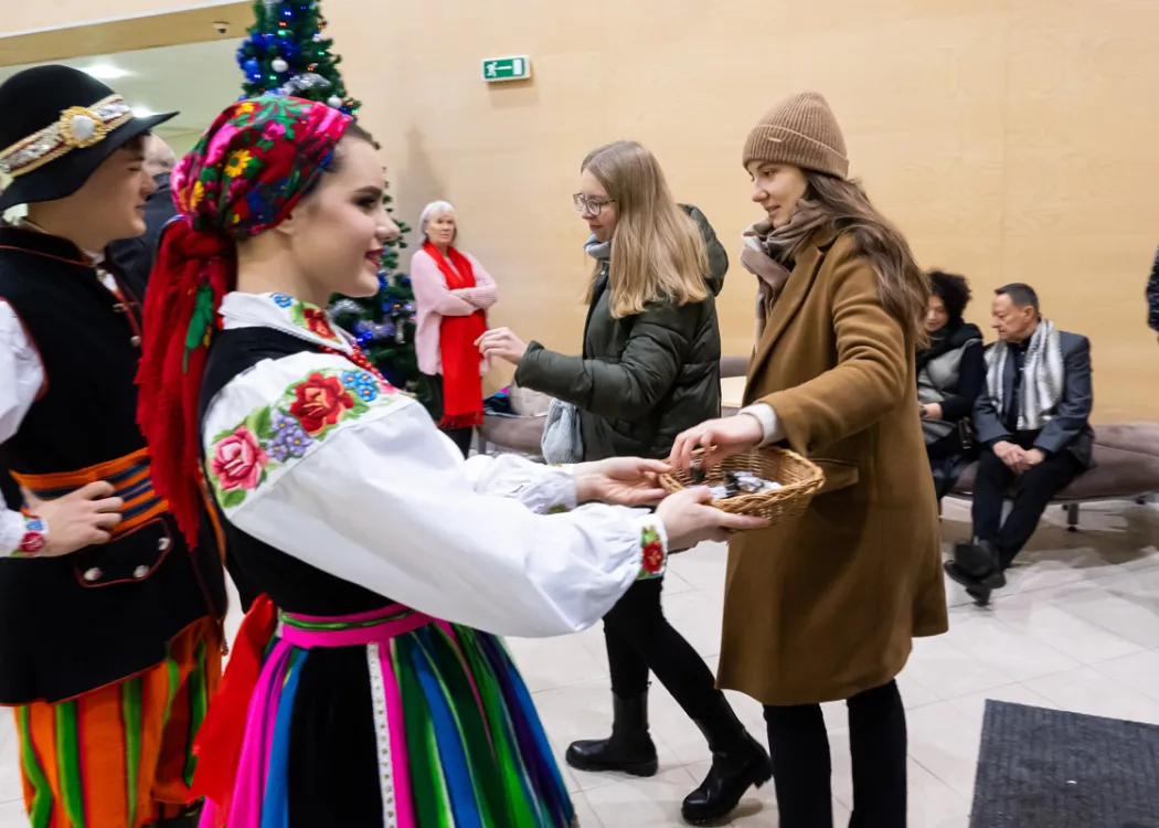 dziewczyna w stroju ludowym wita ludzi