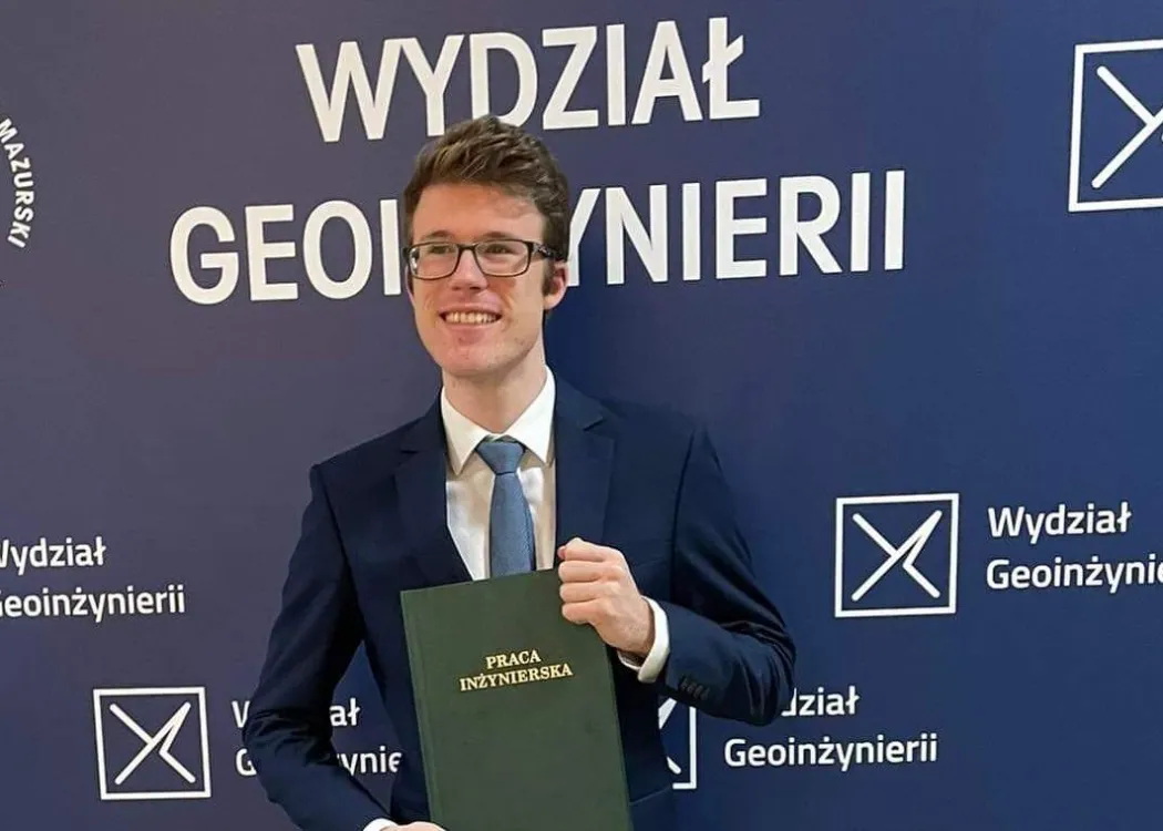 Marek Czołpiński pozuje z pracą inżynierską