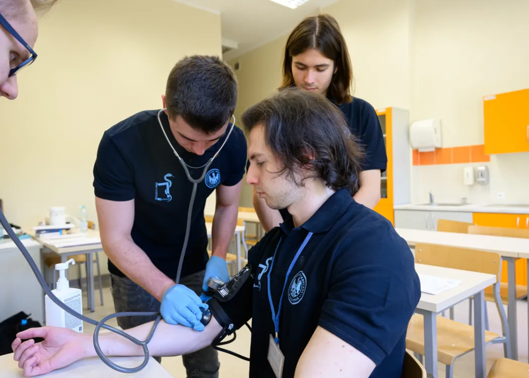 jeden student mierzy drugiemu ciśnienie krwi