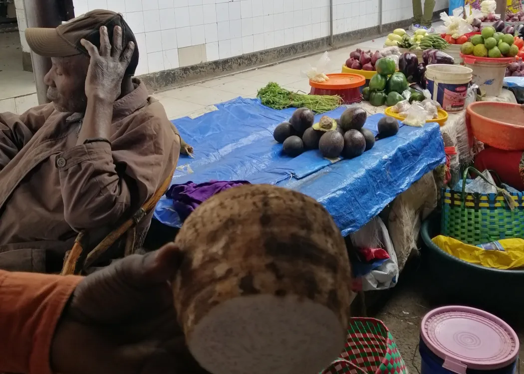 Korzeń manioku, w tle targ na Zanzibarze