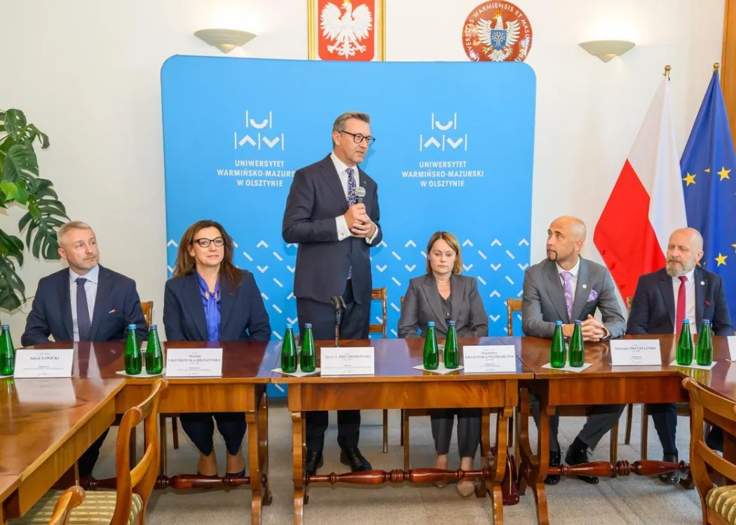 Rektor stoi i przemawia wśród prorektorów 