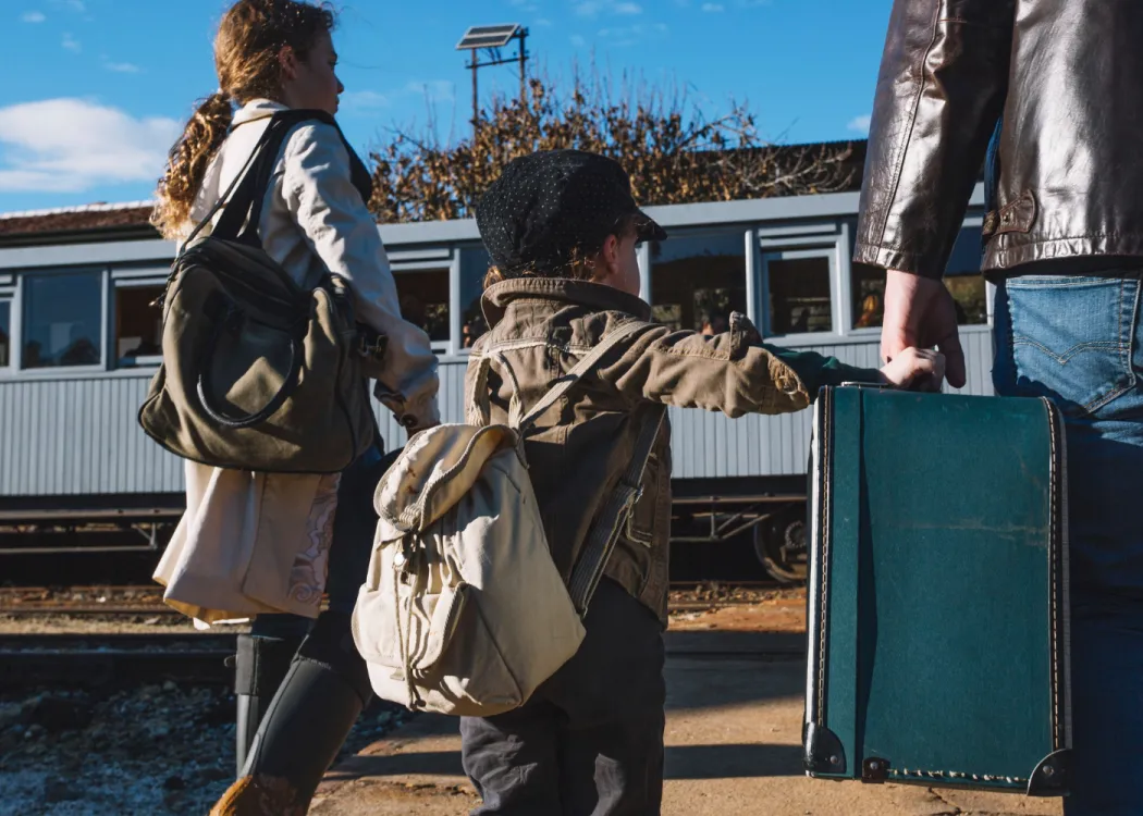 Trzy osoby z walizkami i plecakami