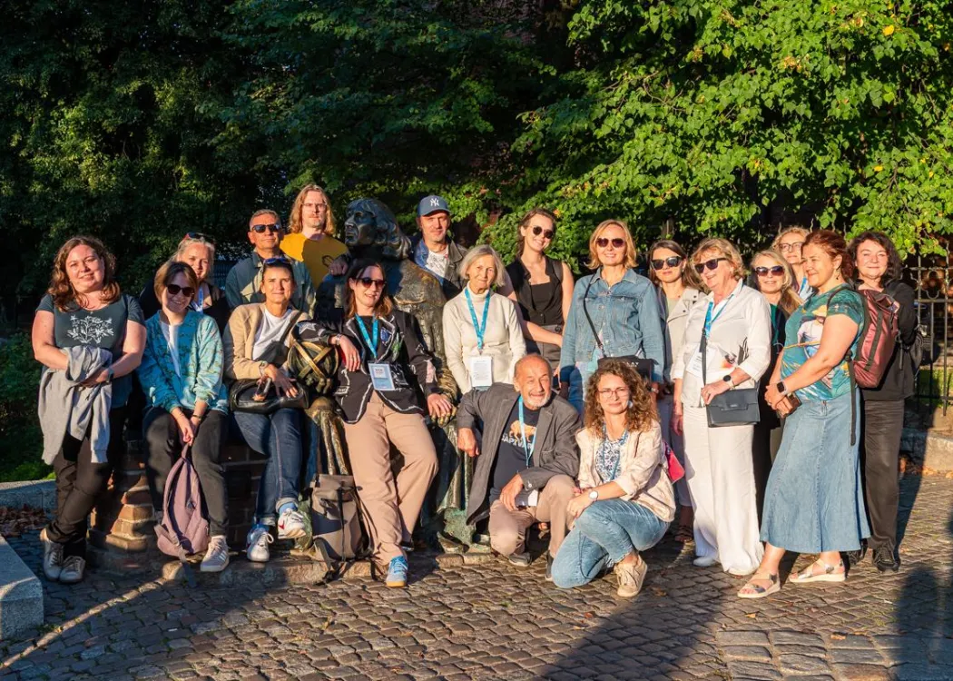 Konferencja redaktorów: uczestnicy konferencji na grupowym zdjęciu przy pomniku Mikołaja Kopernika