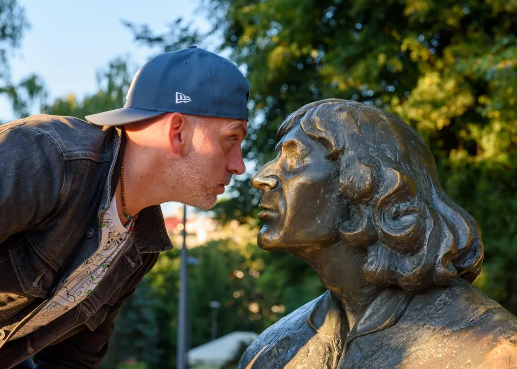 Konferencja redaktorów: uczestnik z pomnikiem Mikołaja Kopernika