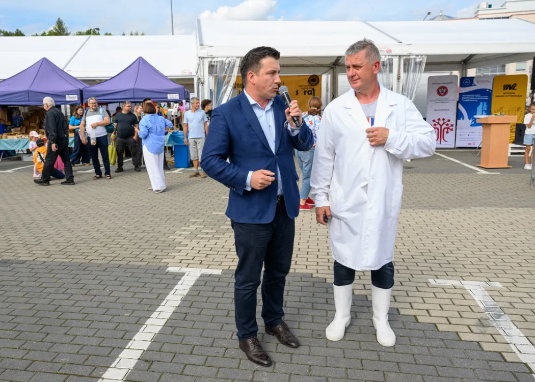 Święto Sera 2025: dwóch mężczyzn rozmawia ze sobą, jeden ubrany jest w biały fartuch i białe gumaki