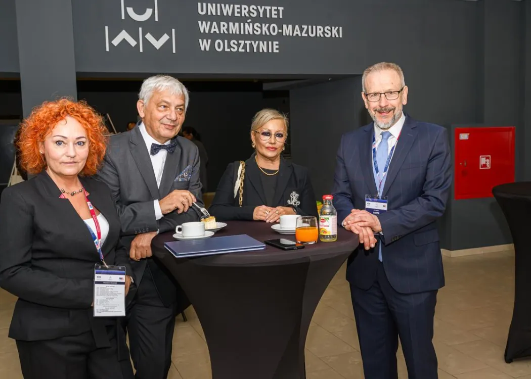 Zjazd pedagogiczny: czwórka organizatorów stoi przy stoliku