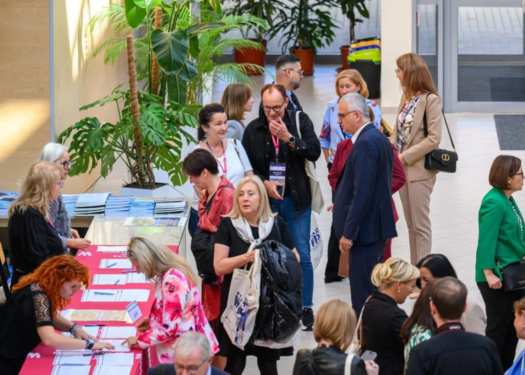 Zjazd pedagogiczny: uczestnicy stoją przy rejestracji 