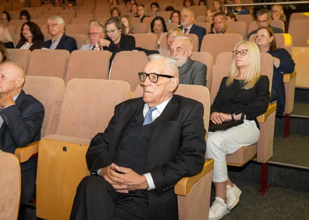 Zjazd pedagogiczny: goście siedzą w sali, na pierwszym planie starszy mężczyzna 