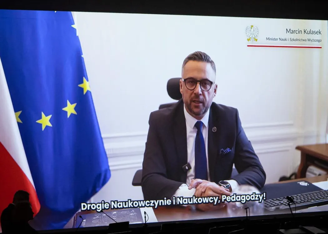 Zjazd pedagogiczny: minister przemawia na ekranie, w tle unijna flaga
