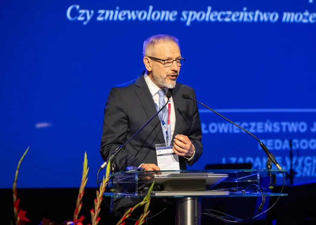 Zjazd pedagogiczny: uczestnik panelu w garniturze przemawia do mikrofonu