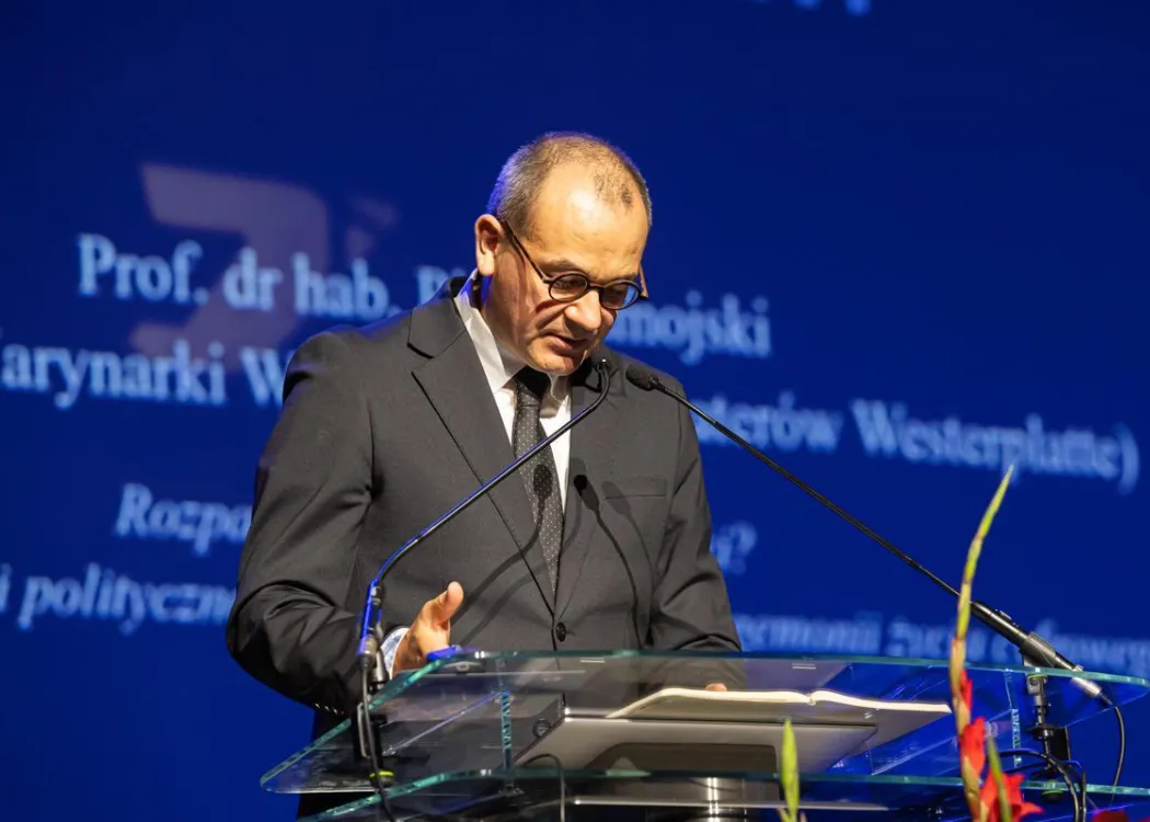 Zjazd pedagogiczny: uczestnik panelu w garniturze przemawia do mikrofonu