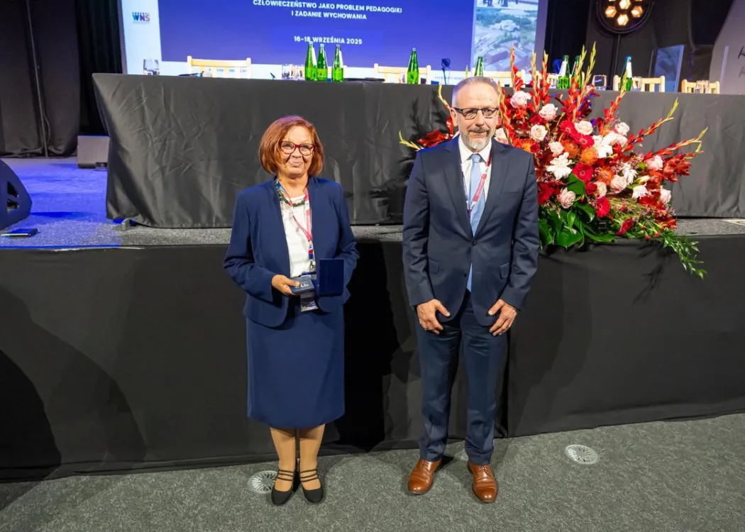 Zjazd pedagogiczny: kobieta stoi z medalem obok mężczyzny