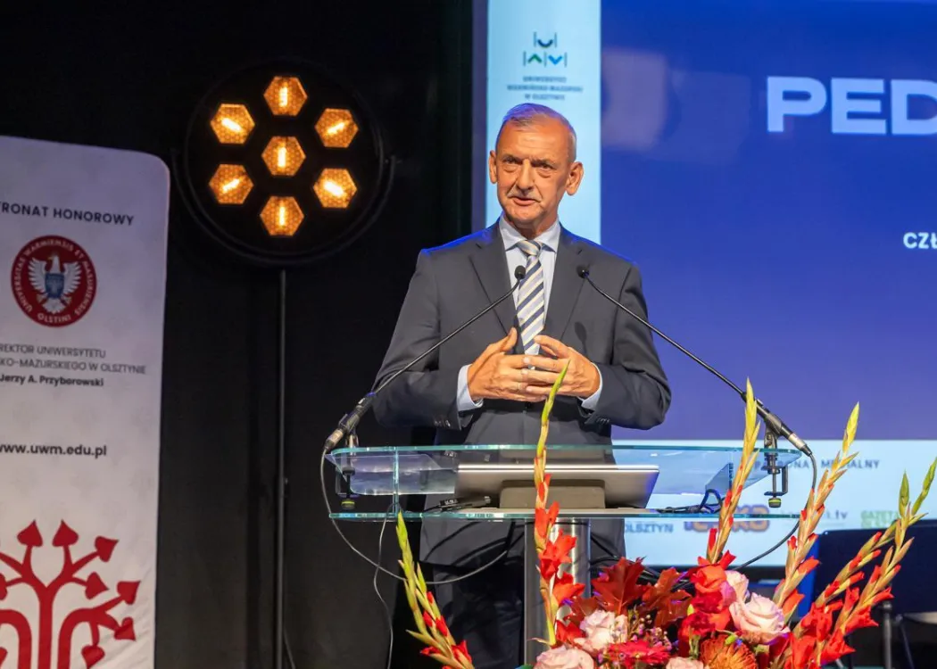 Zjazd pedagogiczny: mężczyzna w garniturze przemawia do mikrofonu