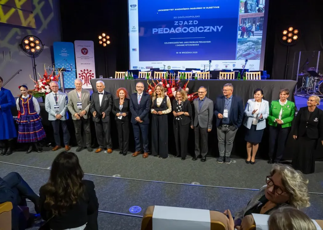 Zjazd pedagogiczny: kilka osób stoi przed sceną