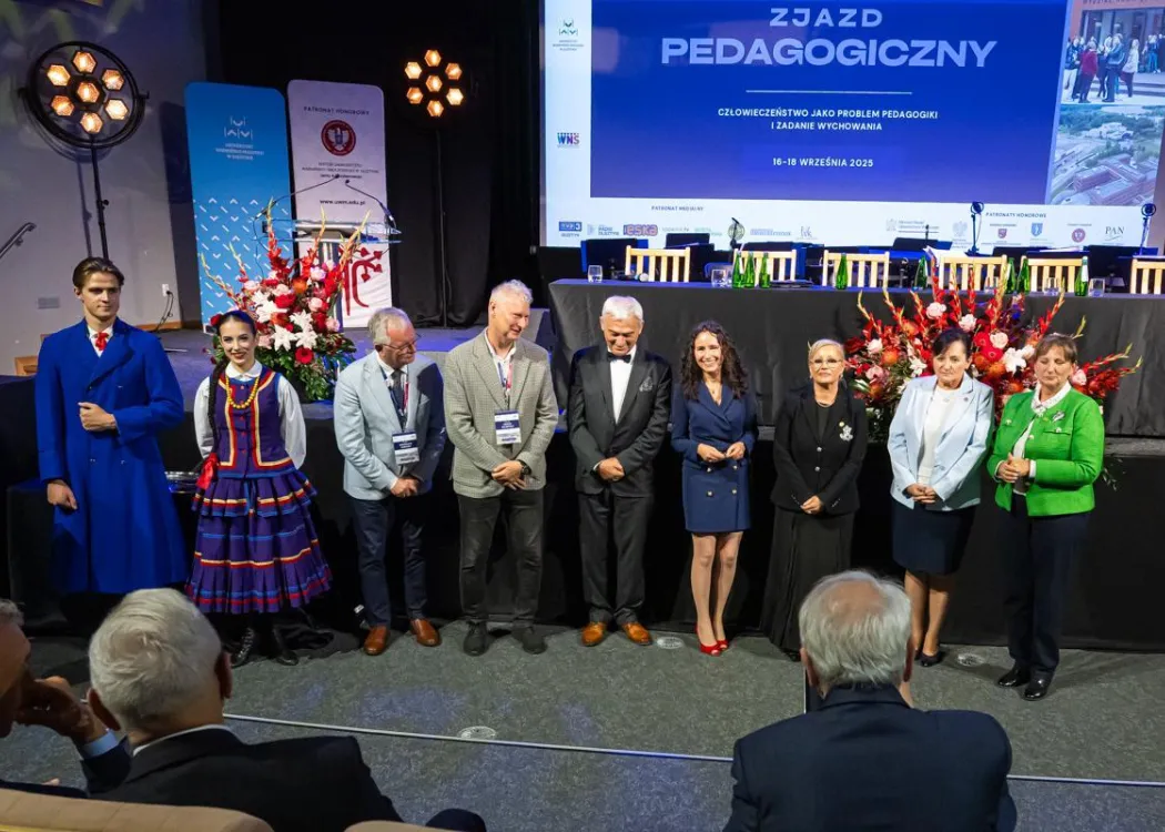 Zjazd pedagogiczny: kilka osób stoi przed sceną