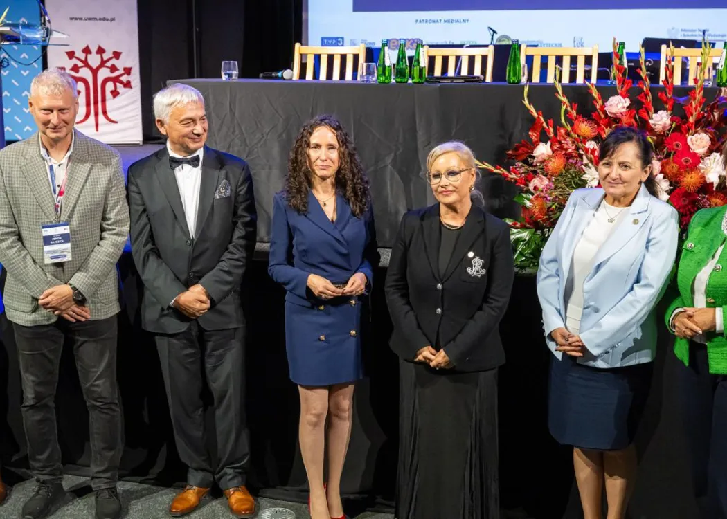 Zjazd pedagogiczny: kilka osób stoi przed sceną 