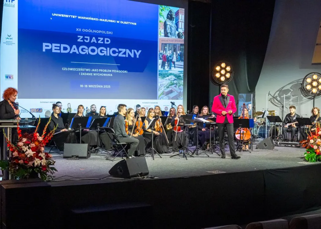 Zjazd pedagogiczny: na scenie orkiestra muzyczna z dyrygentem 